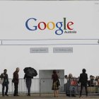 Fotografía de archivo que muestra varias personas delante de un mural que imita el buscador de Google en Sídney.