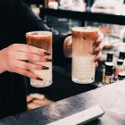 Caso. Una mujer sostiene dos bebidas en restaurante.