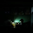 Comercio. Una trabajadora de un restaurante en Urdesa prepara un plato a la luz de una lámpara recargable, para atender a un cliente.