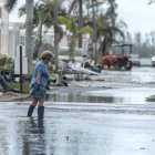 Una mujer camina por una calle inundada tras el paso del huracán Milton en Bradenton, Florida.