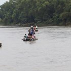 Migrantes cruzan en pequeñas embarcaciones el río Suchiateen