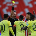 Jugadores de Ecuador discuten con el árbitro Raphael Claus una tarjeta amarilla para Pervis Estupiñán (c) en el partido Ecuador vs Paraguay