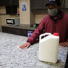 Limpieza. Una persona desinfecta con un cloro sin etiqueta.