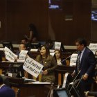 Algunos asambleístas llevaron carteles a la sesión.