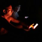 Personas observan su celular durante un apagón este viernes 18 de octubre, en La Habana, (Cuba).