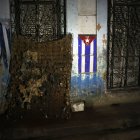 Fotografía de un colchón dañado junto a una bandera de Cuba durante un apagón este viernes, en La Habana.