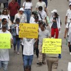Manifestantes sostienen carteles en una marcha este sábado 19 de octubre en San Salvador (El Salvador).