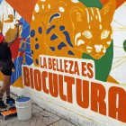 Una mujer pinta un mural este sábado 19 de octubre en Cali. La ciudad colombiana levantará este domingo el telón de la cumbre COP16.