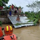 Un grupo de guardacostas acude en ayuda de una familia en una zona inundada.