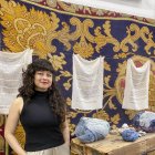 La artista colombiana Vanessa Nieto posa junto a una de sus obras expuestas en la Real Fábrica de Tapices, en el marco de la exposición "Reencuentros para tejer la vida y los afectos". EFE/Patricia Cotelo Bertaiola