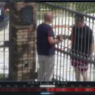 Roma. Un par de personas intercambian dinero tras una reja.