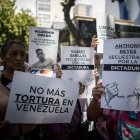 Personas con carteles que muestran imágenes de detenidos durante una manifestación frente a la sede del Ministerio de Servicio Penitenciario, en Caracas.