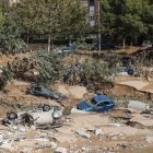 Varios vehículos permanecen semienterrados entre el lodo tras el paso de la DANA, este jueves en Paiporta, Valencia.