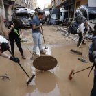 Vecino y personas de diversas comunidades autónomas trabajan como voluntarios para restablecer la normalidad en Alfafar (Valencia), este viernes.