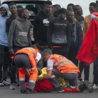 Un inmigrante es atendido a su llegada al puerto de Arrecife en Lanzarote entre un grupo de personas que intentaban llegar a las costas canarias, este domingo 3 de noviembre.