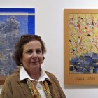 La artista palestina Vera Tamari posa junto a su obra en la exposición Pósteres de Gaza.