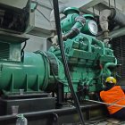 Empresa. Un trabajador da mantenimiento a un generador eléctrico industrial para que funcione las 24 horas.