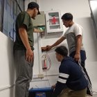 Estudiantes de la Universidad de Cuenca indican las instalaciones eléctricas que permiten transformar la energía de su aula a solar cuando hay cortes de luz.