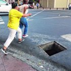 Ciudadanas cerca de caer en la alcantarilla por cruzar la calle.