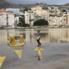 Una mujer camina junto a un aparcamiento público anegado, en Cullera, ciudad que se ha visto afectada por fuertes lluvias esta madrugada aunque sin causar graves incidentes.