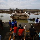 Aldeanos filipinos observan un puente dañado afectado por el tifón Usagi, en el municipio costero de Santa Ana, provincia de Cagayán, Filipinas, el 15 de noviembre de 2024.