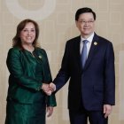 a presidenta de Perú, Dina Boluarte (i), saluda al jefe ejecutivo de Hong Kong, John Lee Ka-chiu (d).