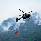 Fotografía cedida por el Cuerpo de Bomberos de Cuenca de un helicóptero combatiendo un incendio forestal en el Parque Nacional Cajas, en Cuenca (Ecuador).