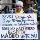 Una mujer sostiene una pancarta durante una vigilia este domingo, en Caracas (Venezuela).