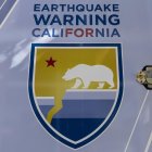 Un cartel que dice "Advertencia de terremoto en California" en un simulador de terremoto móvil, en Los Ángeles, California, EE. UU.