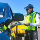 Agente civil de tránsito, en un procedimiento, en una vía en Quito.
