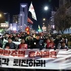 Miembros de la Confederación de Sindicatos de Corea del Sur y grupos cívicos portan una gran pancarta mientras marchan hacia la oficina presidencial durante una manifestación que pide la destitución
.