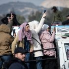 Personas celebran montadas en la parte trasera de un vehículo tras la captura de la ciudad de Damasco por parte de los rebeldes sirios.