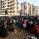 Miembros detenidos de las fuerzas de seguridad del gobierno sirio son reunidos en un campo.