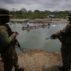 Agentes del Servicio Nacional de Fronteras vigilan la llegada de migrantes que cruzan la selva del Darién con rumbo a los Estados Unidos, en Bajo Chiquito (Panamá).