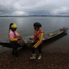 Fotografía del 9 de diciembre de 2024 de dos mujeres recolectoras de piangua bajando de una canoa, en la vereda La Plata de Bahía Málaga (Colombia). EFE/ Ernesto Guzmán Jr.