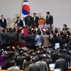 Los legisladores del gobernante Partido del Poder Popular discuten con el presidente de la Asamblea Nacional, Woo Won-shik este viernes.