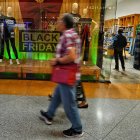 La gente camina frente a una tienda durante una venta del Viernes Negro en Caracas el 29 de noviembre de 2024.