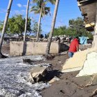 Un hombre camina por viviendas destruidas en la costa de la comunidad de Cedeño (Honduras).