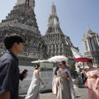 Turistas extranjeros vestidos con trajes tradicionales tailandeses visitan el Templo del Amanecer, o Wat Arun, en Bangkok, Tailandia, el 6 de enero de 2025.