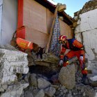 Un rescatista busca sobrevivientes en una casa con un perro de rescate después de un terremoto en el municipio de Cuoguo en Shigatse, región del Tíbet, suroeste de China, el 8 de enero de 2025.