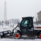 Una máquina quitanieves limpia una acera cerca del Monumento a Washington en la Explanada Nacional en Washington, DC, EE. UU.