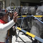 Una partidaria del expresidente Evo Morales, hace un gesto frente a agentes de la policía antidisturbios durante la marcha "Comunales por la Vida" contra el gobierno de Luis Arce