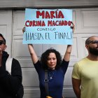 Una mujer sostiene un cartel que dice "María Corina Machado, contigo hasta el final" durante una protesta convocada por la oposición en vísperas de la toma de posesión presidencial en la Ciudad de México