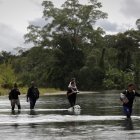 Migrantes que cruzan el río Tuquesa luego de atravesar la selva del Darién, frontera natural entre Colombia y Panamá.