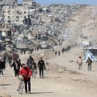 Palestinos caminan en una calle de Jabalia entre los escombros de edificios destruidos mientras los desplazados se dirigen a las zonas del norte de la Franja de Gaza.