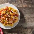 En la salchipapa no pueden faltar la salsa de tomate y mayonesa.