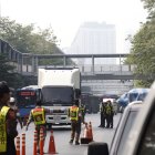 Los funcionarios de tránsito monitorean los vehículos en los puntos de control para detectar emisiones de humo como parte de una campaña de reducción de la contaminación en Bangkok