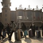 Varios turistas caminan caminoa a la estación de trenes de Pekín.