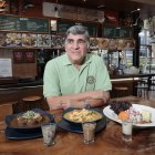Rodeado de sus creaciones insignia, refleja su pasión por la gastronomía.