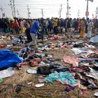 Devotos caminan cerca de telas mezcladas en el suelo tras un accidente por estampida durante el festival Kumbh Mela cerca de Sangam Ghat Prayagraj, Uttar Pradesh (India).